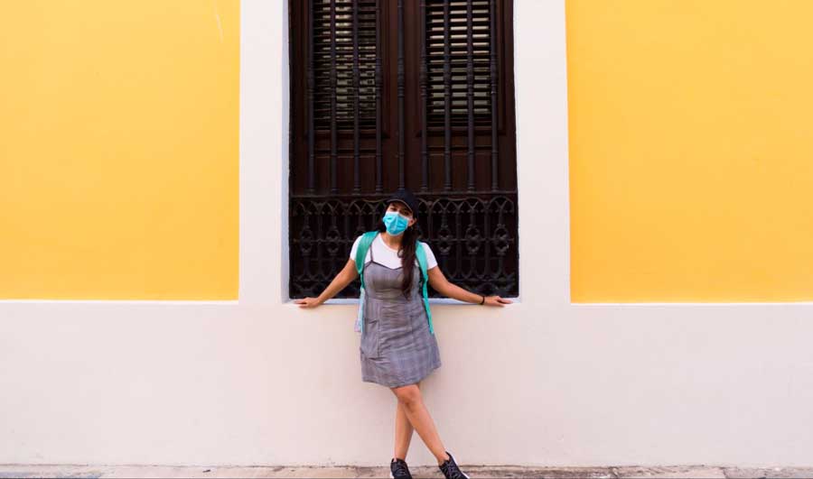 The author posing against the vibrant yellow wall