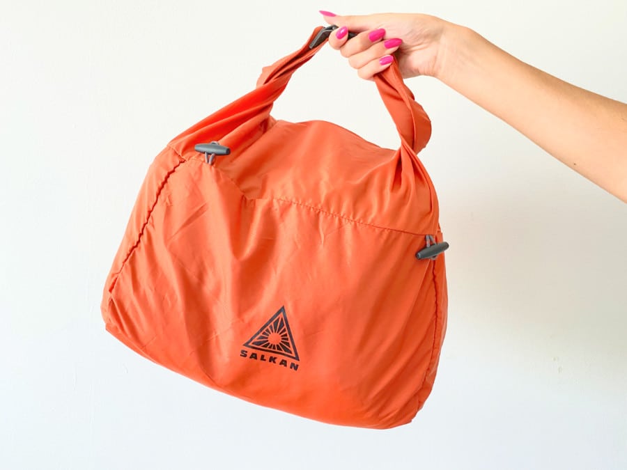 A hand holding the Salkan laundry bag