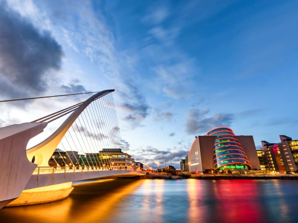 View of the illuminated Samuel Beckett Bridge and Dublin Convention Center from Dublin Docklands at dusk