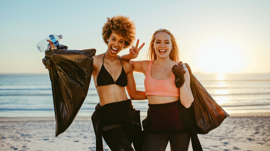 View of two surfers volunteer for beach cleanup in San Diego