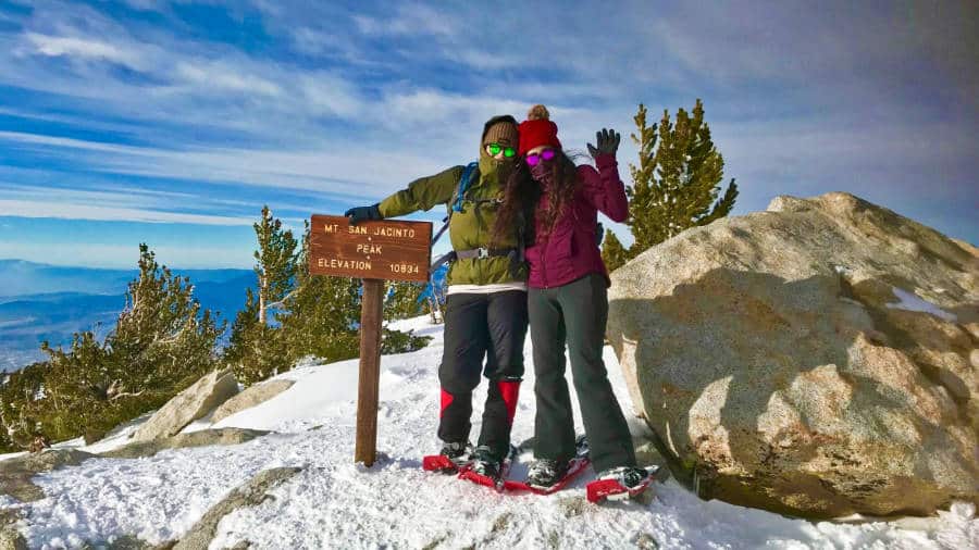 The author McKenna Mobley with her best friend posing at the summit of San Jacinto Peak during winter