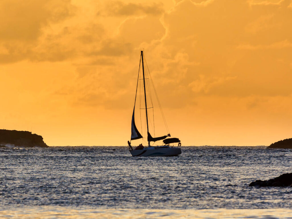 Scenic view of the sunset and the boat sailing in the middle of the water