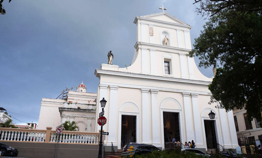 View of the San Juan Cathedral from the outside and some people going inside the church