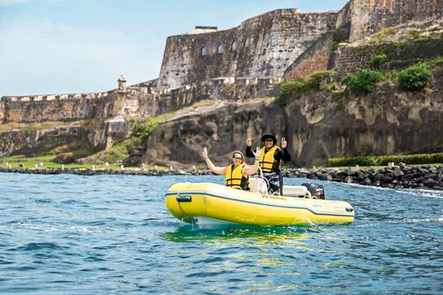 Two people posing on the mini boat in San Juan