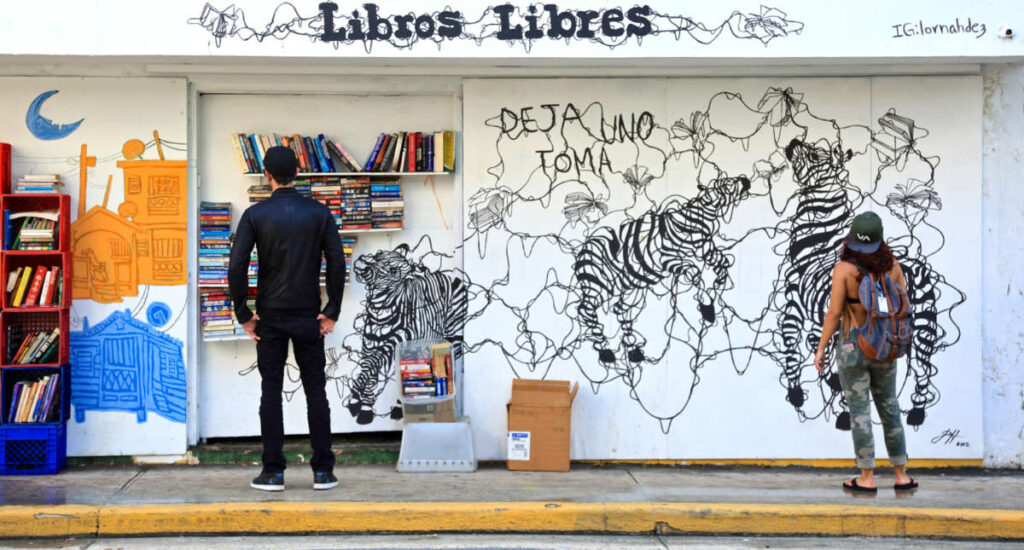 View of the people looking the mural and the displayed books at the San Juan Public Library