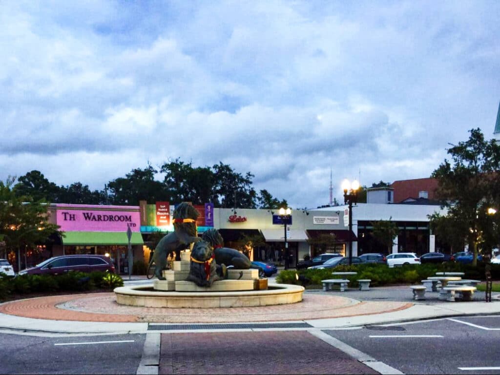 View of the statue of lions surrounded by shops and parked cars in San Marco Square