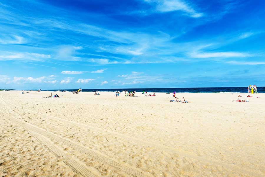 View of people in the Sandy Hook Beach and the clear blue sky above it
