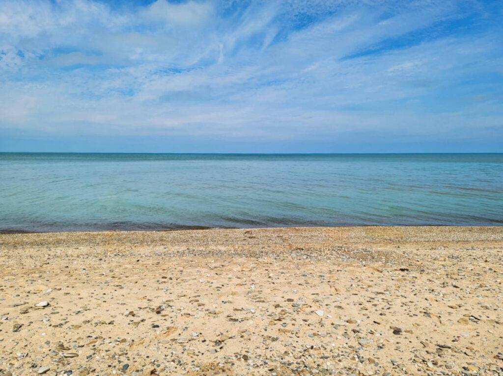 View of the calm water from the white sandy Lake Michigan Beach