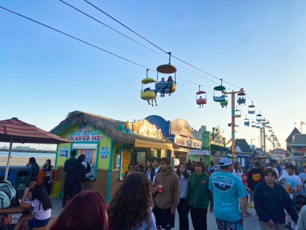 View of the aerial lifts above the crowded boardwalk carnival at sunset