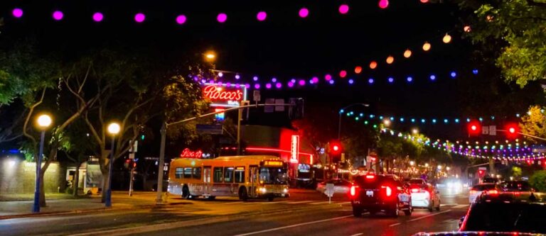 Cars driving along a road with light installation at night in Santa Monica Boulevard