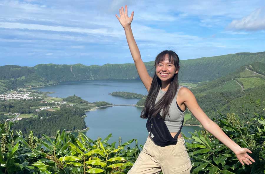 The author posing for a photo with one of the viewpoints in Sao Miguel on her background