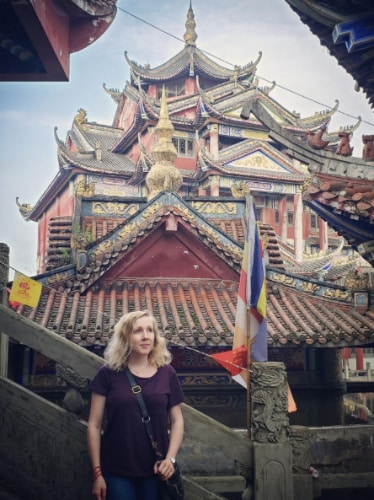 Sarah Heath with a Temple on her background in rural China