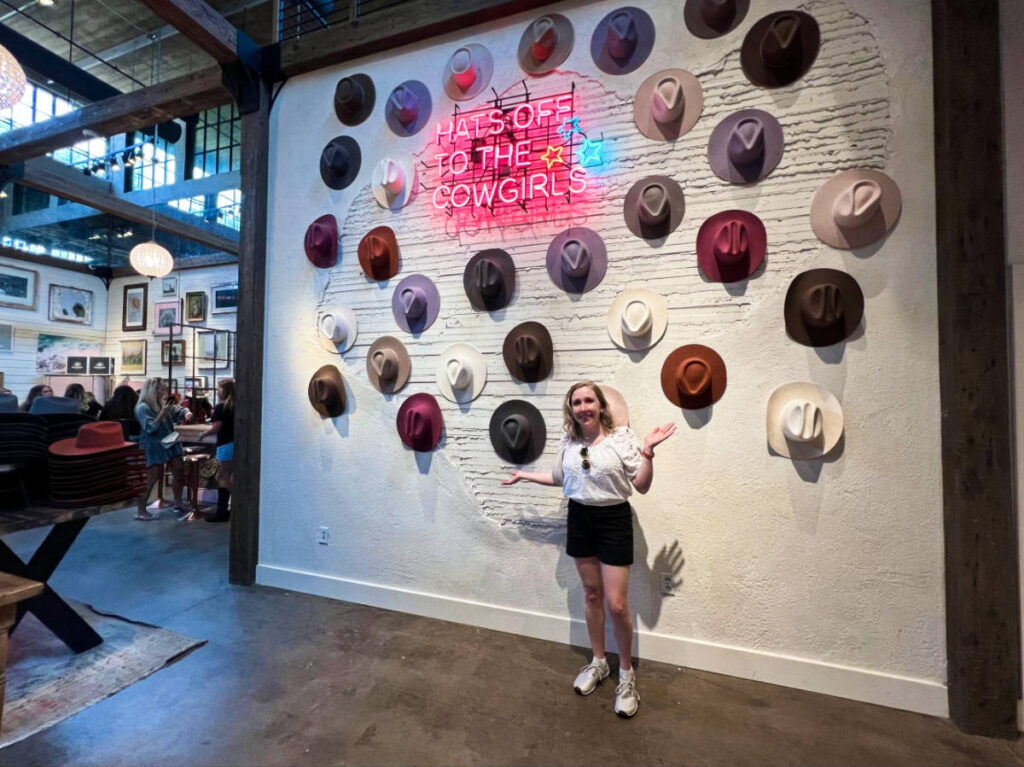 The author Sarah Heath, at the entrance signage with cowboy hats inside Flea Style