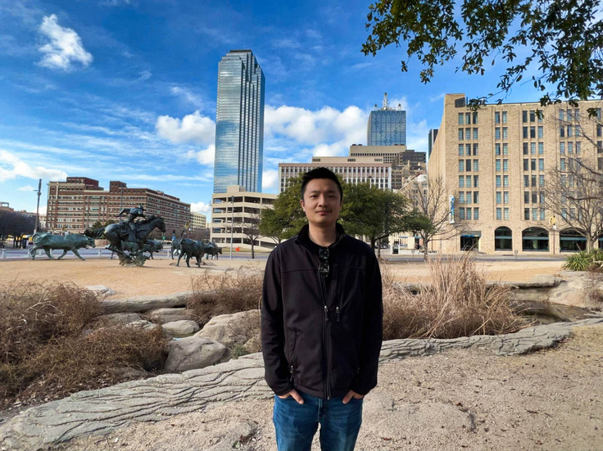 The author Sarah Heath's husband, posing for a photo at the Dallas Cattle Drive Sculptures in Downtown Dallas