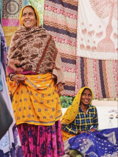 Two women dressed in vibrant sarees