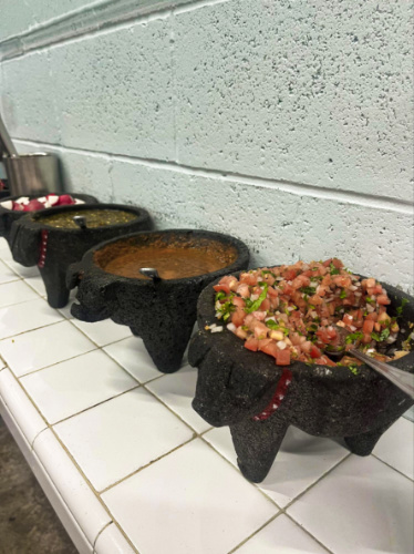 View of the selection of sauces and pico de gallo from Los Tacos