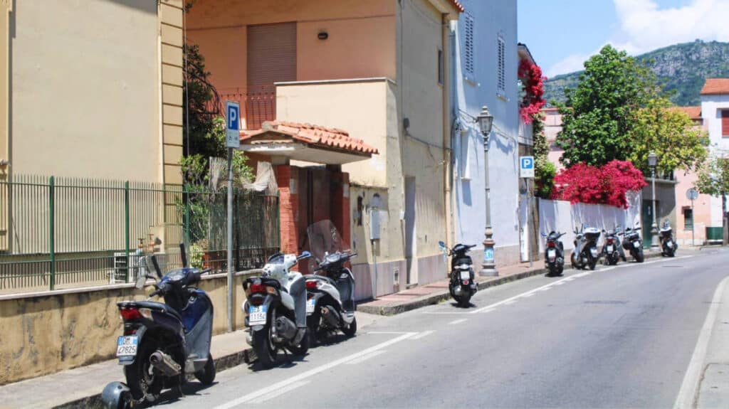Scooters parked on the side of a street