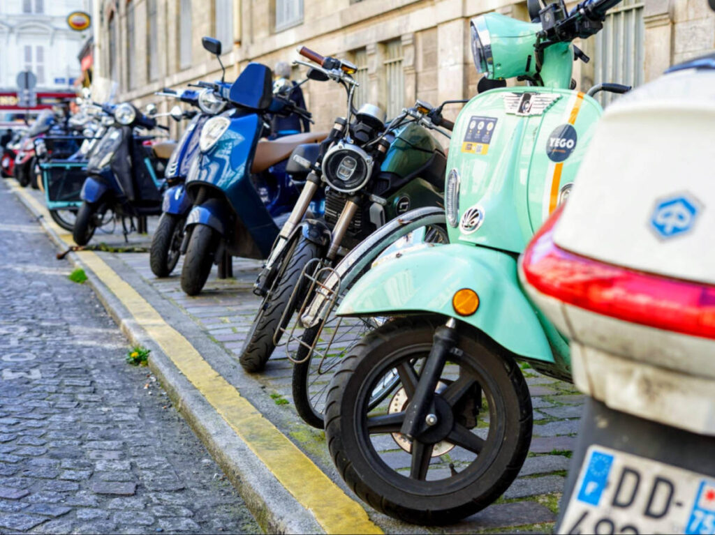 View of colorful scooters parked on a street in Montmartre