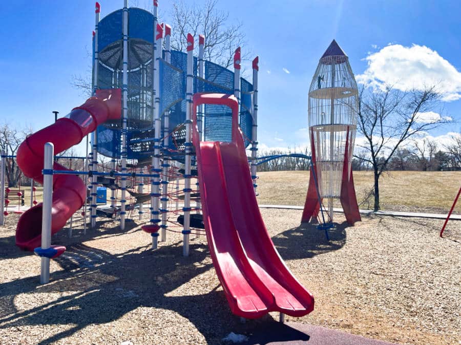 View of the bright red playground equipment at Scott Carpenter Park