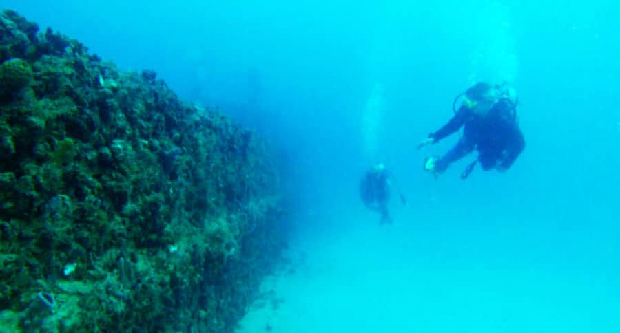 Two scuba divers and a shipwreck under the water of Fort Lauderdale