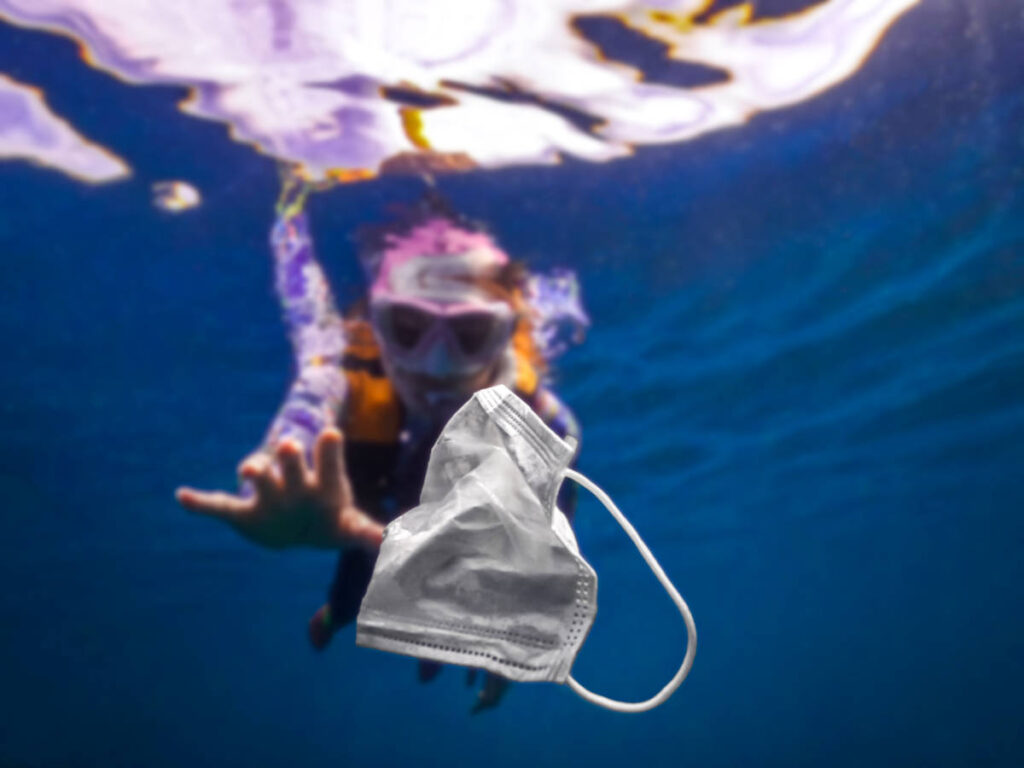 A scuba diver picking up the trash under the water