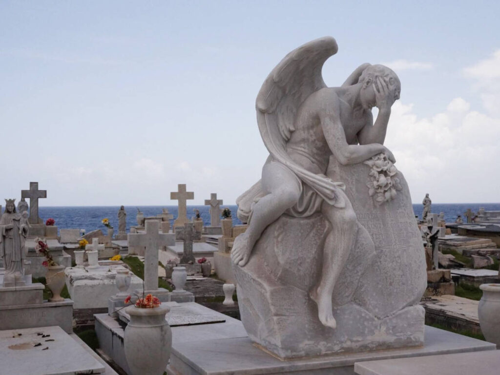 An angel sculpture on a tomb in a cemetery