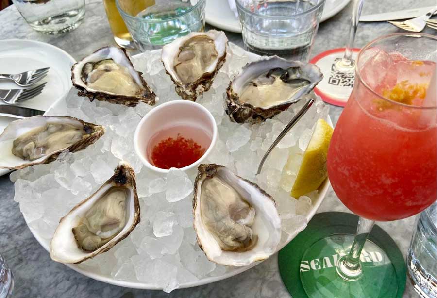 Fresh oysters on ice and glasses of cocktail