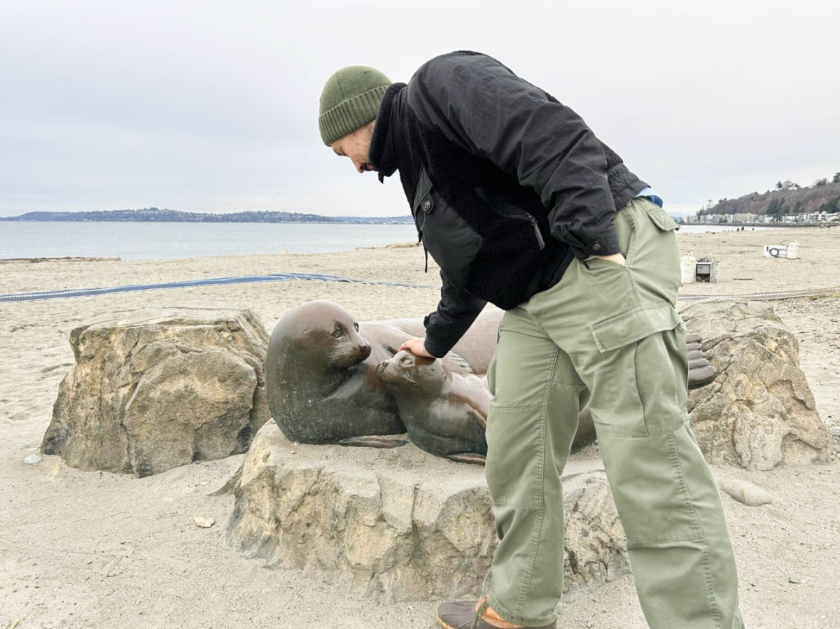 The author's husband touching the seal statue at the Alki Beach