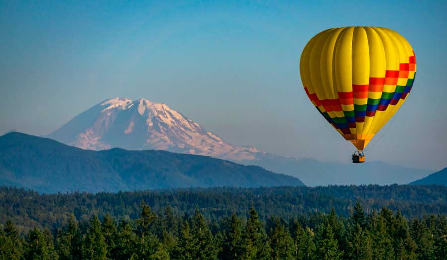 A colorful hot air balloon and the Mt Rainier on the background
