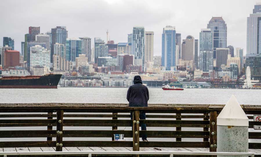A man admiring his view of Seattle during a rainy day
