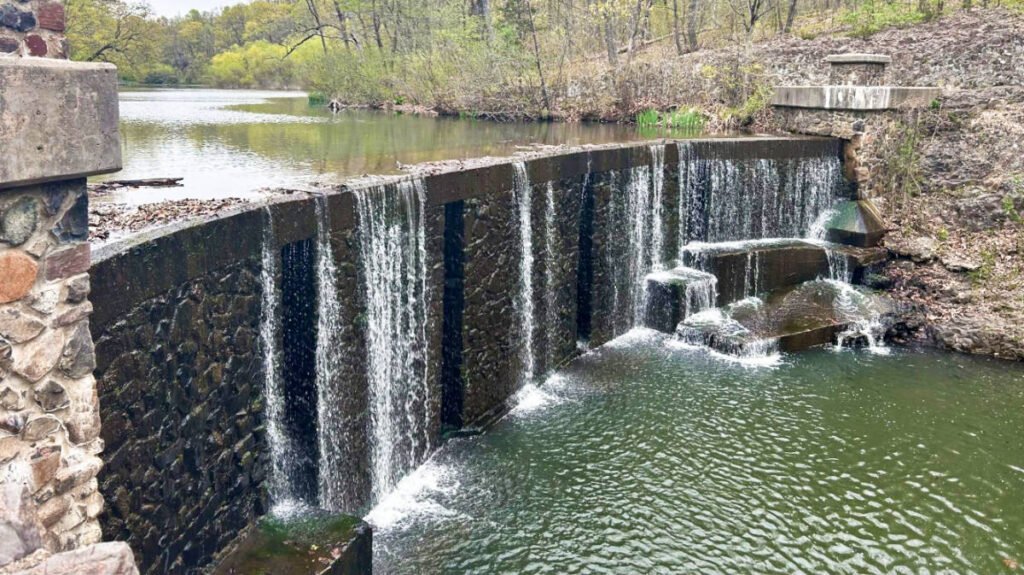 View of the Seeley’s Pond Waterfall cascading down the stone wall in Watchung Reservation