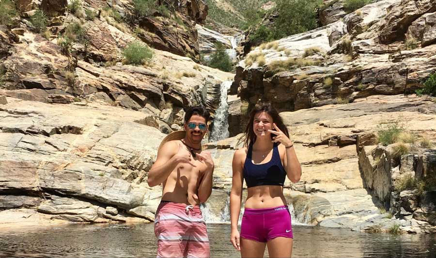 The author with a friend posing for a photo with the Seven Falls on their background