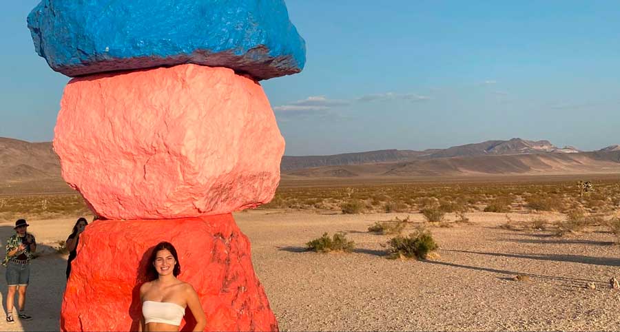 The author posing for a photo with the colorful rocks in Seven Magic Mountains