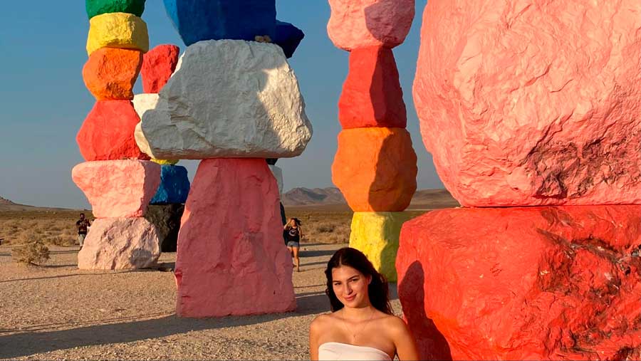 The author posing for a photo with the colorful art installation in Seven Magic Mountains