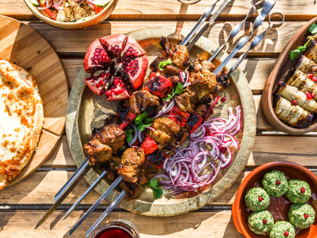 A plate of Shish kebab with other Georgian dish on the side