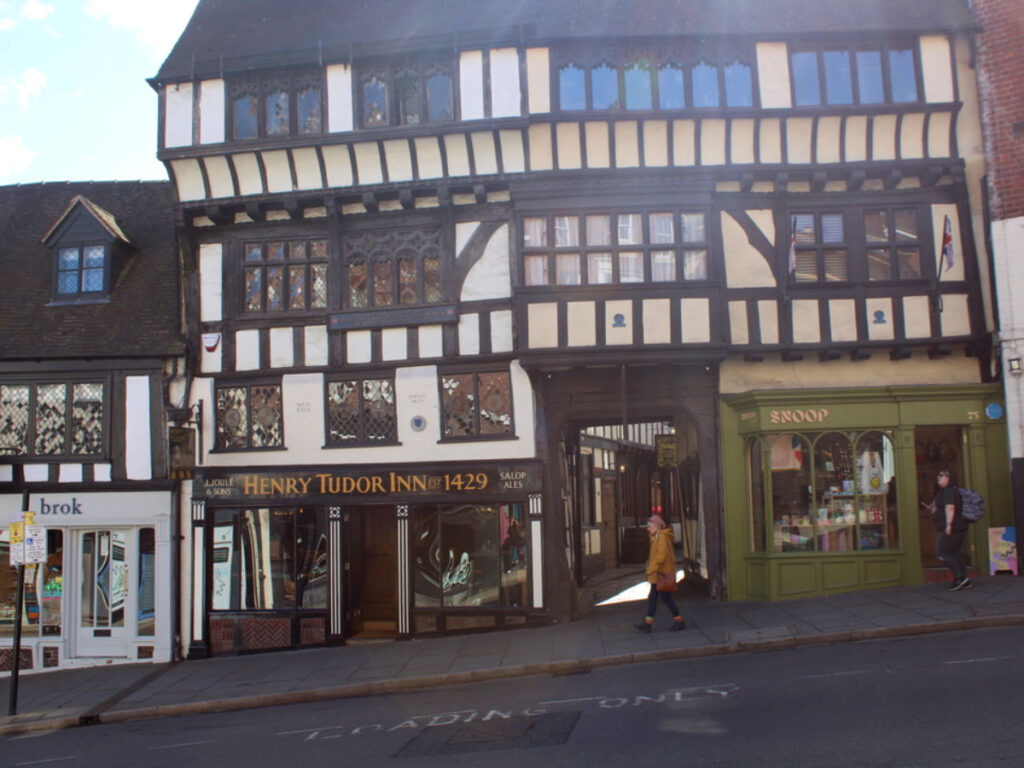 A person walking by some shops in Shrewsbury