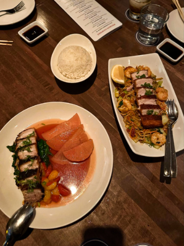 The pork belly “sinigang” and pancit canton on a wooden table in Sunda New Asian