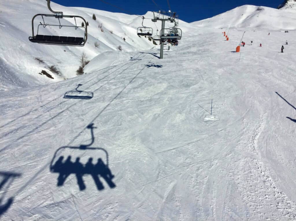 View of the ski lifts over the snow covered slope in the French Alps