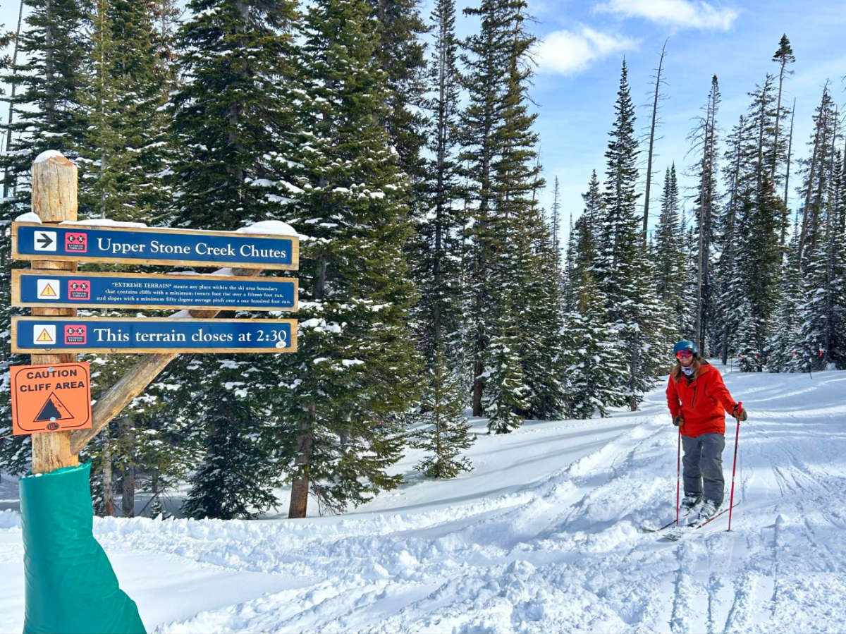 A skier near the signages of Upper and Lower Stone Creek Chutes at Beaver Creek Resort 