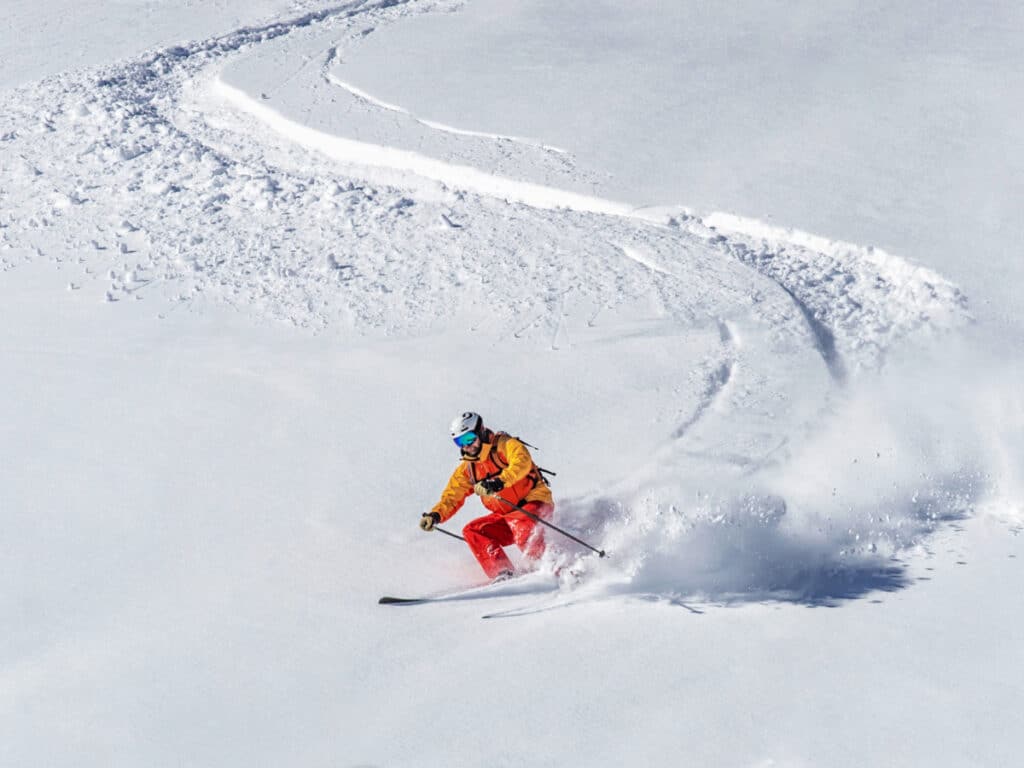 A skier going down the sill of the powdery snowscape