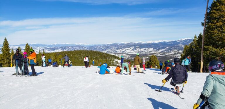 View of skiers and snowboarders preparing to go down a ski slope in Colorado ski resort
