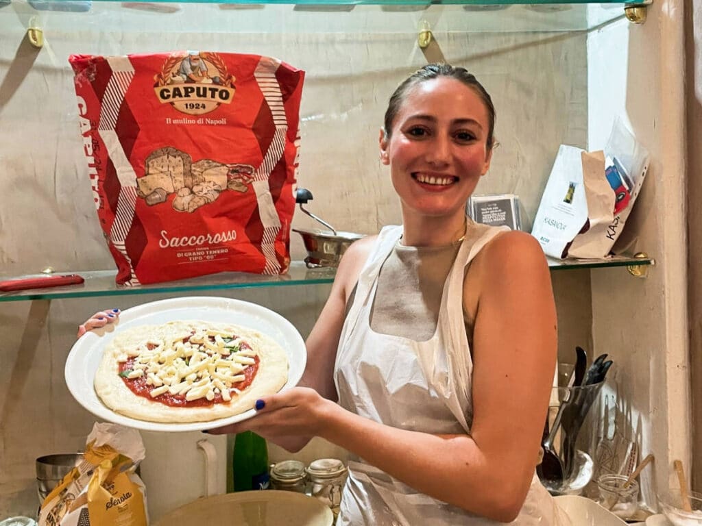 The author Sky Ariella, showing her pizza from the pizza-making class in Naples
