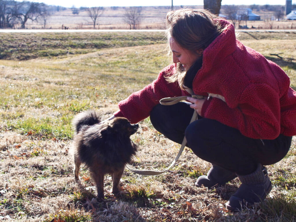 Travel Lemming Writer Sky Ariella, petting the head of her dog