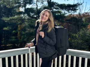 The author Sky Ariella wearing a jacket and her backpack at the balcony