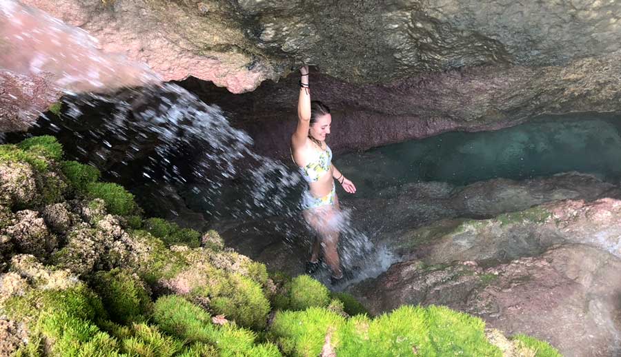 The author enjoying her day from a waterfall