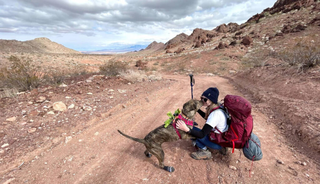Skycie with her dog on a trail using the Osprey Aura AG LT 65