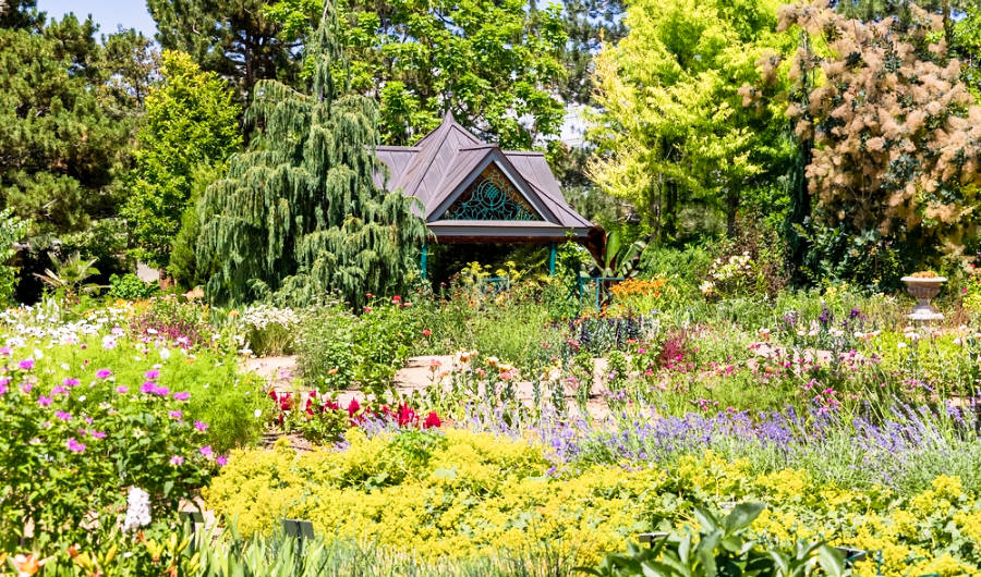 View of the small pavilion surrounded with blooming colorful flowers at Denver Botanic Gardens