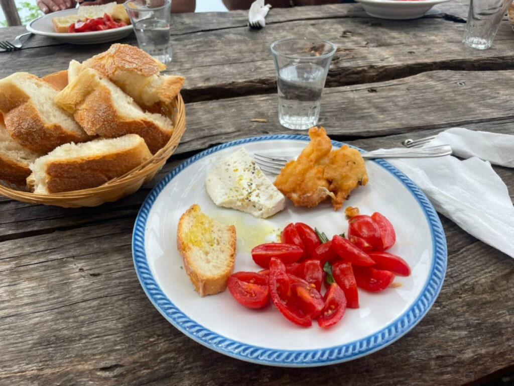 Homemade cheese, fried squash blossom, and fresh tomatoes in a plate
