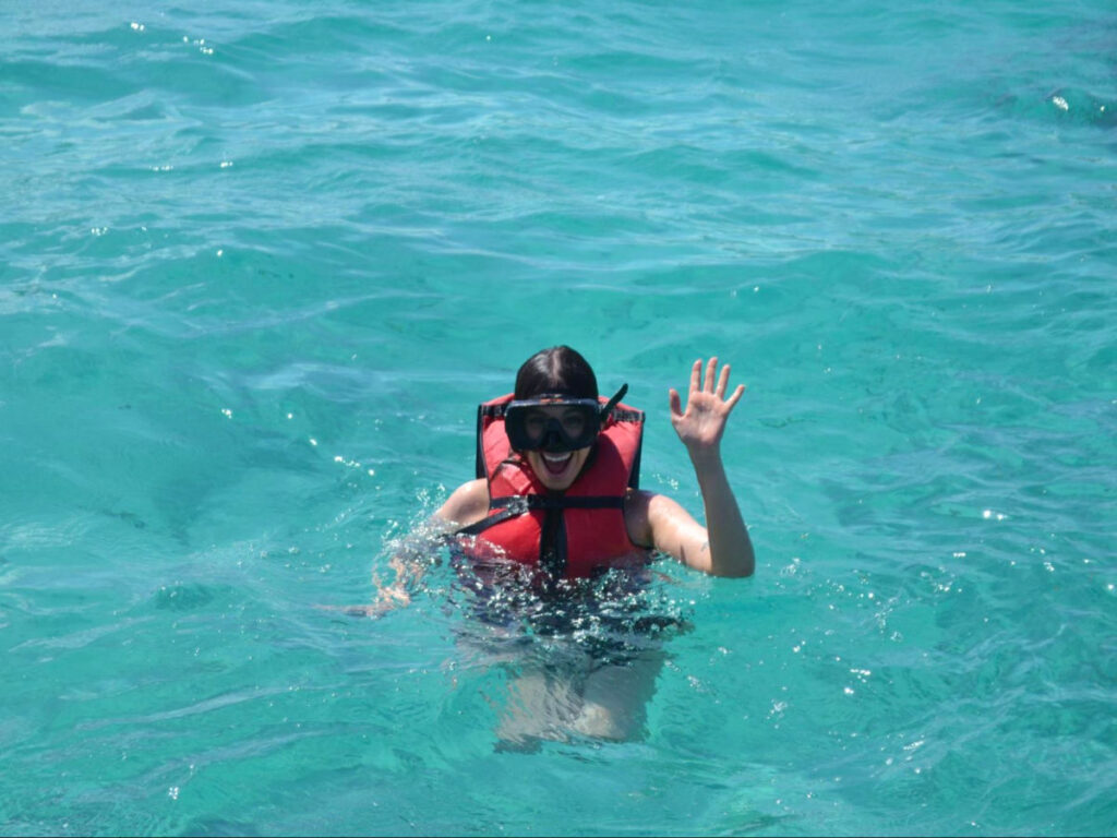 Author Claudicet waving from the water during her snorkeling excursion in Punta Cana