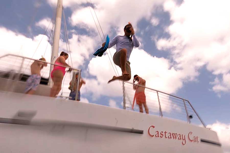 View of people on a boat and a woman jumping from the boat